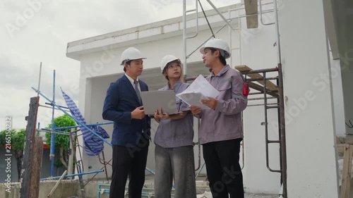 Construction inspector safety helmet blueprint laptop teamwork building site architecture engineer project planning professional discussion outdoor industrial structure workwear collaboration