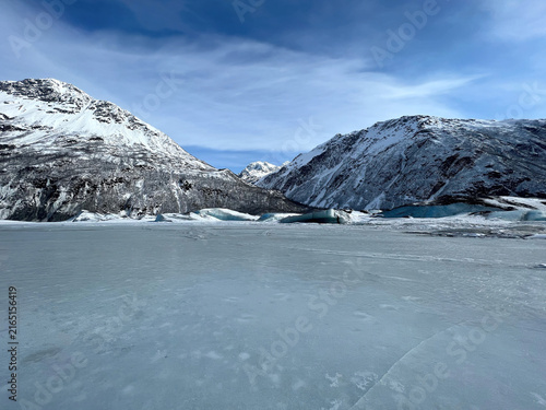 Frozen lake with mountains in the background on a winter day in Alaska. 
