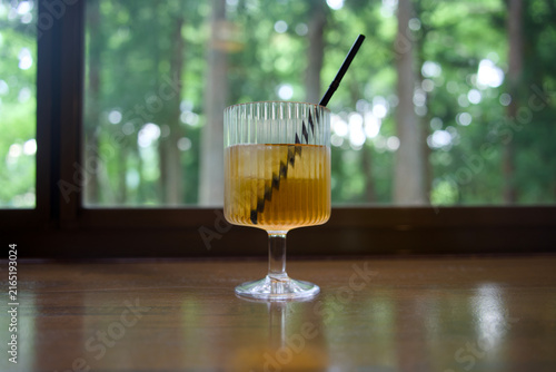 Fotografía Iced Tea in Stemmed Glass on Wooden Counter by Window