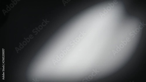 A soft white light beam sweeps across a dark surface in a seamless loop