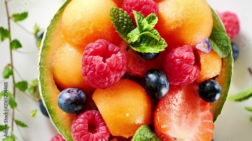 Fresh fruit salad with melon berries and mint leaves top view
