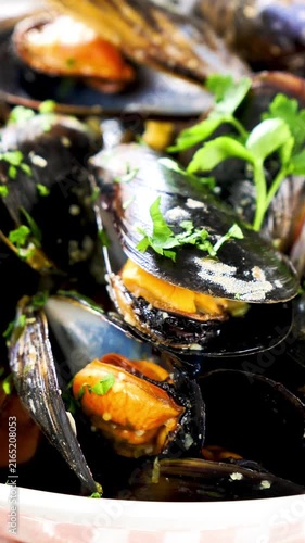Fresh cooked mussels with parsley closeup seafood dish, vertical footage