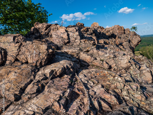 Quadro su tela View from the top of Černolické skály in Czechia, with rugged Ordovician quartzite rocks overlooking a vast green forest landscape under a clear blue summer sky