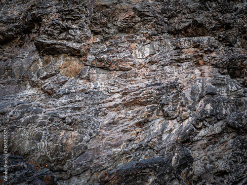 Fotografie Detailed close-up of rugged quartzite rock at Cernolice Rocks in Czechia, showing natural layers, cracks, colors and geological texture of the protected rock formation