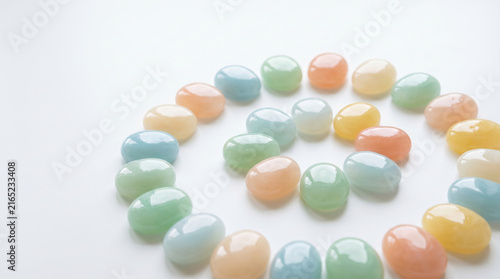 Inflated jelly pebbles in spiral shape with pastel colors on white background creating soft and calming visual effect