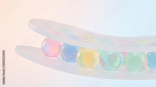 Colorful jelly spheres compressed between translucent plastic layers create soft pastel abstract with gentle light and smooth