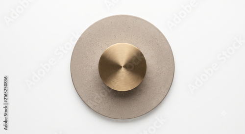 Top-down view of circular micro cement plate and brushed brass cylinder