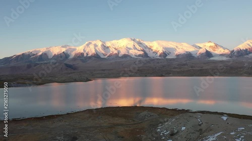 Aerial view of sunrise and golden snow mountain at Karakul Lake and Kongur Tiube Peak in Xinjiang China