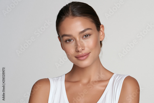 modern woman with warm brown skin and natural beauty, elegant beauty portrait of confident woman with low bun, sophisticated cosmetic campaign portrait with natural makeup