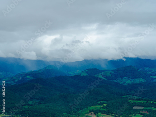 Majestic mountain range covered with dramatic rain clouds and white mist fog