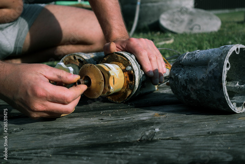 Photography Hands holding worn rubber impeller during submersible water pump repair