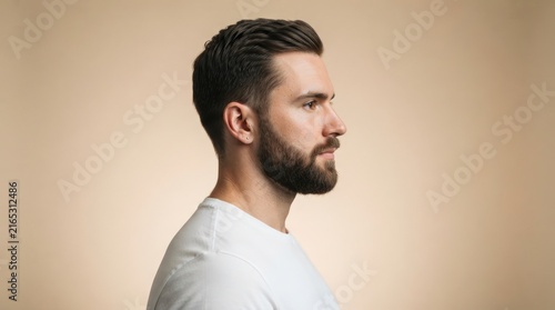High-quality side portrait of a professional man with short hair and beard, ideal for lifestyle marketing, branding, and corporate website backgrounds with a clean, neutral backdrop.