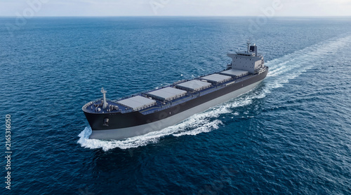 Large cargo ship sailing on open ocean. Maritime transport, shipping industry, global trade, logistics.