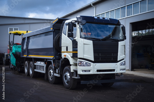 Heavy dump truck parked at a vehicle base. Commercial construction transport ready for work, hauling bulk materials, and operating on construction and industrial sites.
