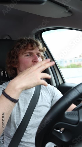 Vertical screen happy driver listens to music and dances behind the wheel enjoying the rhythm while the car moves through urban traffic during a lively and upbeat journey
