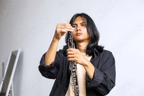 Foto Asian Man Preparing His Classical Oboe with Precision During an Indoor Music Ses