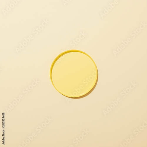 A simple yellow circle on a pale background with soft lighting