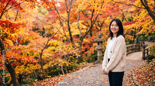 秋の日本庭園を観光する女性と鮮やかな紅葉の風景
