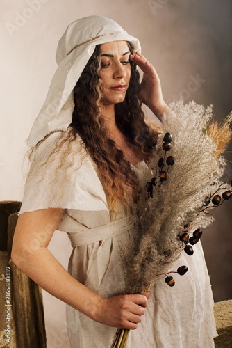 Artistic Maternity Portrait of Pregnant Woman in Medieval Gown with Dried Flowers