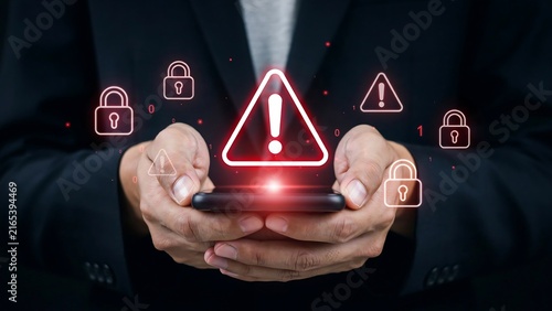 A professional businessman holding a modern smartphone displaying urgent cyber security breach warnings and digital protection locks