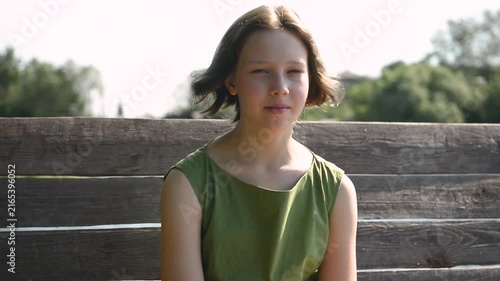 Close-up portrait of a white teenage girl with imperfect skin, looking confidently and naturally at the camera.