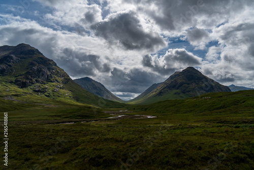 Bild auf Leinwand Dramatic landscape view of a winding river flowing through a lush green valley s