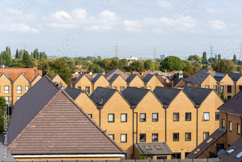 Foto Row of Modern Residential Houses with Brown Roofs Under Overcast Sky in Urban Ar