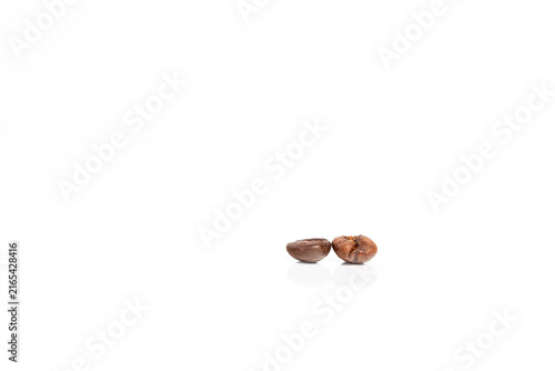Foto Two roasted coffee beans isolated on white background with soft reflection