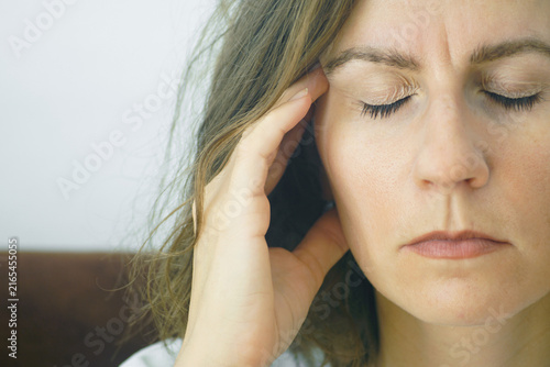 Принти на полотні Close-up of woman touching temple with eyes shut, experiencing throbbing sensation