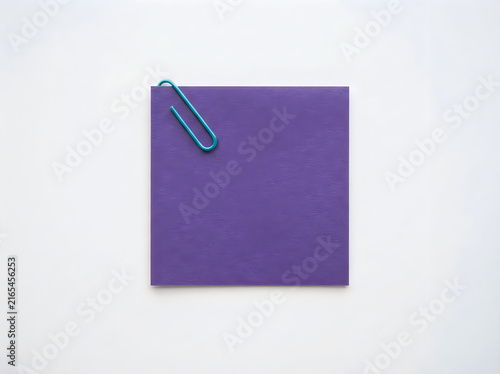 A blank purple square paper note held by a teal metal paperclip isolated on white background
