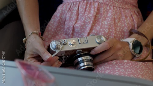 Train journey.  The girl with a film camera in her hands is preparing to take a picture of the summer journey. Interior of the train carriage.