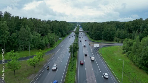 Cinematic top-down aerial drone footage over a highway in Helsinki, Finland, on a cloudy, rainy summer day.