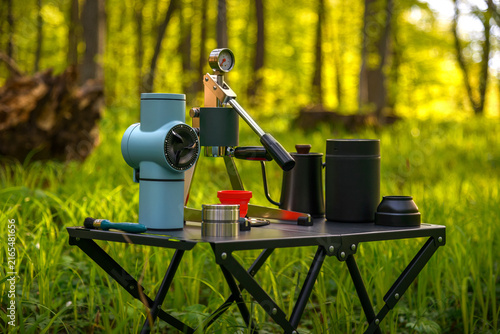 Portable manual espresso coffee setup with grinder and brewing accessories for outdoor camping in a forest