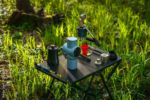 Portable manual espresso coffee setup with grinder and brewing accessories for outdoor camping in a forest
