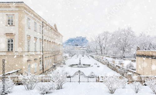Baroque architecture of Salzburg in cold white winter landscape with falling snow and view of fortress Hohensalzburg, castle Mirabell with garden, Cathedral Dom - concept of travel - Austria Europe