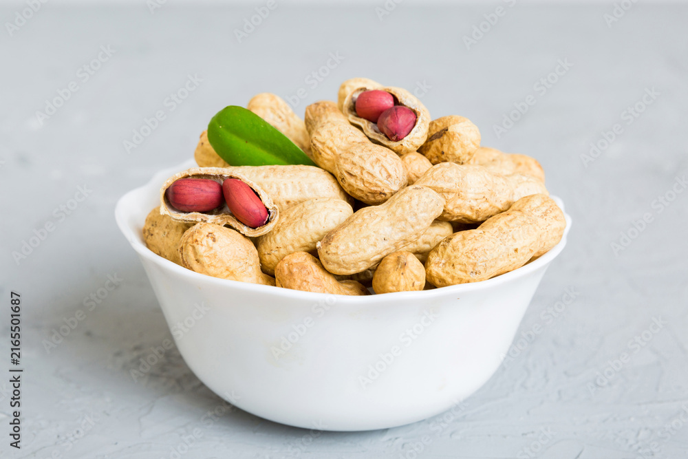 Fototapeta premium Fresh healthy peanuts in bowl on colored table background. Top view Healthy eating bertholletia concept. Super foods