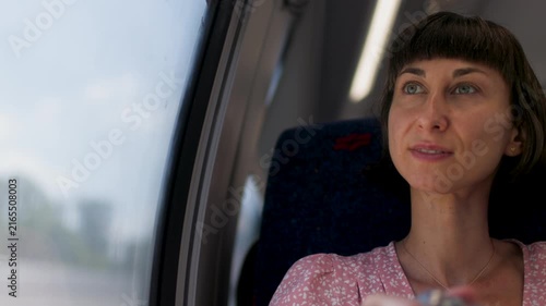Girl tourists, travels and smiles she uses a camera to take photos on the train. summer trip. girl in late