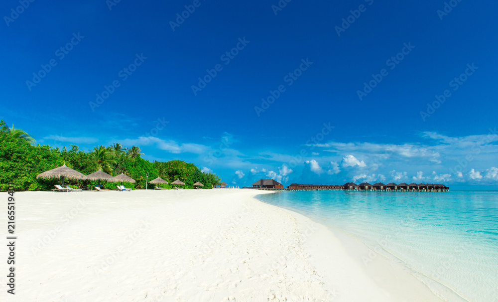 Fototapeta premium Tropical beach with turquoise ocean, palm leaves and blue sky