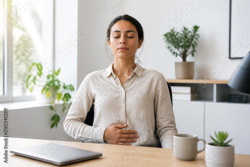 Office Worker Practicing a Brief Calming Breathing Exercise beside a Closed Laptop during a Mindful Break in a Modern Home Workspace