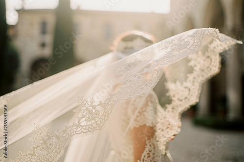 Windblown bridal veil close up with elegant lace details at outdoor wedding venue