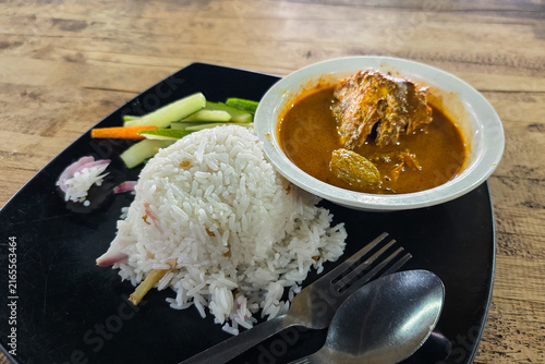 Canvas Print Close-up on a serving of authentic Nasi Dagang with tuna or ikan tongkol with gravy and pickles