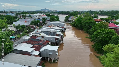 Drone view of muddy floodwater surrounding homes and greenery in An Giang, Vietnam, during the annual Mekong Delta flood season.