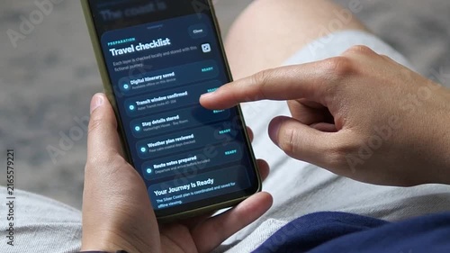 Traveler reviews a digital trip checklist on a smartphone, organizing itinerary, transit, lodging, weather and route details for a smooth, connected journey.