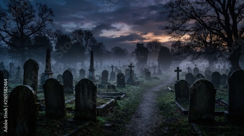 Foggy cemetery with old gravestones at night for Halloween horror backgrounds, haunted attraction marketing and ghost stories.