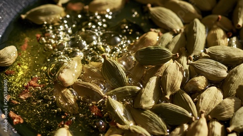 Green pods are sizzling in hot oil with small bubbles forming.