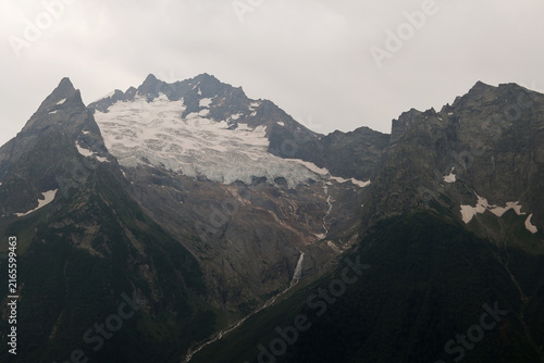 Alpine mountain peaks with glaciers and a waterfall