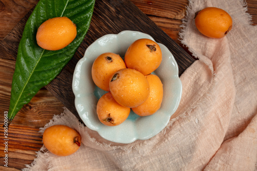Canvastavla Fresh Loquats in Ceramic Bowl on Rustic Wooden Table