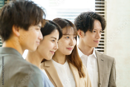 Obraz w ramie オフィスで並んで立つ若い日本人の男女の顔のアップ