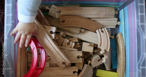 Baby child hand choosing toy from box  seen from above
