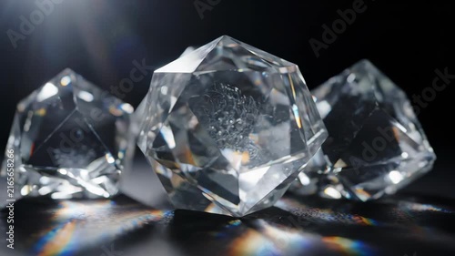Raw uncut diamonds sparkling with light on a dark reflective surface.
